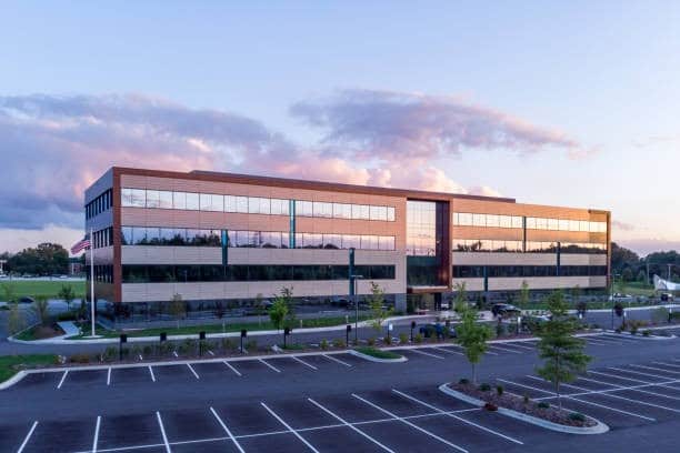 Evening shot of office building exterior with large parking lot